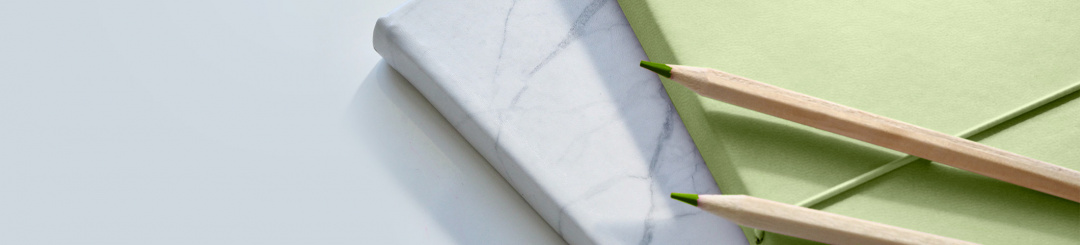 two pencils on a green book