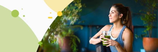 Young women holding a jar with green smoothie